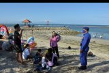 Polisi menegur wisatawan yang tidak menggunakan masker saat liburan Tahun Baru Islam 1442 Hijriah di Pantai Sanur, Denpasar, Bali, Kamis (20/8/2020). Pengunjung di objek wisata tersebut membludak sehingga petugas menertibkan warga yang tidak menerapkan protokol kesehatan terutama penggunaan masker. ANTARA FOTO/Nyoman Hendra Wibowo/nym.