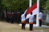Keluarga pewaris Diaraja Kerajaan Aceh Darussalam mengibarkan bendera merah putih  saat mengikuti upacara adat di Banda Aceh, Aceh, Kamis (20/8/2020). Upacara adat berlangsung sederhana di tengah pandemi COVID-19 yang dihadiri keluarga pewaris kerajaan dengan diawali pengibaran bendera merah putih dan kemudian bendera Alam Pedang Kerajaan Aceh Darussalam digelar setiap 1 Muharam itu sebagai simbul pemersatu dan penyemangat rakyat Aceh dan sekaligus melestarikan budaya nusantara dalam semangat NKRI. Antara Aceh/Ampelsa.