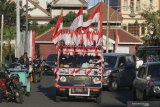 Mobil berbendera Merah Putih yang dikendarai oleh Iyon Haryono (52) melintas di Jalan Garuda, Surabaya, Jawa Timur, Jumat (21/8/2020). Aksi memperingati HUT ke-75 Kemerdekaan Republik Indonesia dengan mengendarai mobil berbendera Merah Putih dari kota Bandung menuju Bali itu telah tiba di Surabaya. Antara Jatim/Didik/Zk