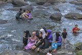 Wisatawan berenang di Sungai Cileueur Kawasan Wisata Cadas Ngampar, Desa Gunungsari, Kecamatan Sadananya, Kabupaten Ciamis, Jawa Barat, Sabtu (22/8/2020). Destinasi wisata alam Cadas Ngampar yang dikelola oleh Badan Usaha Milik Desa (BUMDes) Gunungsari tersebut menyajikan wisata air sungai yang jernih dari kaki gunung sawal dengan hamparan bebatuan besar. ANTARA JABAR/Adeng Bustomi/agr