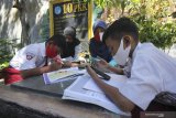Sejumlah pelajar didampingi orang tuanya belajar secara daring di Mulyorejo Selatan Baru, Surabaya, Jawa Timur, Selasa (25/8/2020). Pengurus kampung di tempat itu menyediakan wifi gratis bagi pelajar yang terkendala biaya kuota internet untuk belajar secara daring. Antara Jatim/Didik/Zk