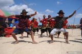 Pemilik sambil mengendalikan sapi menari saat kontes sapi sonok (hias) di Lapangan Socah Center, Waru Barat, Pamekasan, Jawa Timur, Sabtu (29/8/2020). Kontes yang digagas Paguyuban Sapi Sonok Madura itu diikuti lebih dari 100 pasang sapi hias.  Antara Jatim/Saiful Bahri/zk