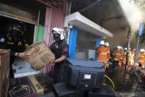 Petugas  mengevakuasi barang-barang toko elektronik yang terbakar di Jalan Kranggan, Surabaya, Jawa Timur, Minggu (30/8/2020). Sekitar 22 kendaraan pemadam kebakaran dikerahkan untuk memadamkan kebakaran yang menewaskan lima orang di dalam toko tersebut. Antara Jatim/Didik/Zk