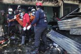 Petugas mengevakuasi korban dari toko elektronik yang terbakar di Jalan Kranggan, Surabaya, Jawa Timur, Minggu (30/8/2020). Sekitar 22 kendaraan pemadam kebakaran dikerahkan untuk memadamkan kebakaran yang menewaskan lima orang di dalam toko tersebut. Antara Jatim/Didik/Zk