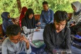 Para penyandang tunanetra belajar membaca Quran braille sambil bermain di Wisata Mandiri Sayang Kaak, Desa Handapherang, Kabupaten Ciamis, Jawa Barat, Minggu (30/8/2020). Saung Quran Bunda menggelar acara mengaji Alquran braille bagi para penyandang disabilitas sekaligus mengenalkan suasana alam sambil berwisata kepada mereka. ANTARA JABAR/Adeng Bustomi/agr