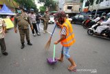 Pelanggar protokol kesehatan mendapatkan sanksi kerja sosial menyapu jalan di kawasan Pasar Lima Banjarmasin, Kalimantan Selatan, Selasa (1/9/2020). Sebagai upaya pencegahan dan pengendalian COVID-19, Pemerintah Kota Banjarmasin menerapkan sanksi denda sebesar Rp100 ribu serta sanksi sosial bagi warga yang tidak menggunakan masker saat beraktivitas diluar rumah. Foto Antaranews Kalsel/Bayu Pratama S.