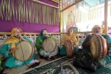 Sejumlah warga melakukan tradisi Turunani dengan menabuh rebana dan bernyanyi kisah Islam dalam bahasa Gorontalo, di Komisi Pemilihan Umum (KPU) di Kabupaten Bone Bolango, Gorontalo, Jumat (4/9/2020). Pendaftaran peserta bakal pasangan calon Bupati dan Wakil Bupati pada Pemilihan Kepala Daerah (Pilkada) Kabupaten Bone Bolango tahun 2020 digelar dalam nuansa adat dengan menampilkan Turunani dan tarian peyambutan Longgo. (ANTARA FOTO/Adiwinata Solihin)