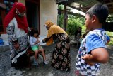 Petugas medis puskesmas Ulee Kareng memberikan suntikan vaksin imunisasi campak dan rubella kepada pelajar di Desa Ilie, Banda Aceh, Aceh, Sabtu (5/9/2020). Petugas kesehatan masyarakat tetap melaksanakan program imunisasi untuk pelajar dengan cara mendatangi satu persatu ke rumahnya pascatidak aktifnya belajar di sekolah masa pandemi COVID-19. Antara Foto/Irwansyah Putra.