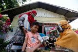 Petugas medis puskesmas Ulee Kareng memberikan suntikan vaksin imunisasi campak dan rubella kepada pelajar di Desa Ilie, Banda Aceh, Aceh, Sabtu (5/9/2020). Petugas kesehatan masyarakat tetap melaksanakan program imunisasi untuk pelajar dengan cara mendatangi satu persatu ke rumahnya pascatidak aktifnya belajar di sekolah masa pandemi COVID-19. Antara Foto/Irwansyah Putra.