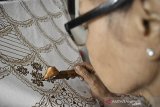 Perajin menyelesaikan pembuatan batik tulis Garutan Asli motif bulu ayam di Kabupaten Garut, Jawa Barat, Selasa (8/9/2020). Selama pandemi COVID-19, perajin batik Garutan Asli tetap memproduksi satu motif batik dalam sebulan guna melestarikan produk asli Garut yang merupakan cerminan dari kehidupan sosial budaya, falsafah hidup dan adat-istiadat orang Sunda. ANTARA JABAR/Candra Yanuarsyah/agr
