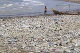 Warga beraktivitas di sekitar sampah yang menumpuk di pantai Dadap, Juntinyuat, Indramayu, Jawa Barat, Rabu (9/9/2020). Sampah yang sebagian besar dari limbah rumah tangga tersebut terseret arus dan menumpuk sehingga mencemari kawasan pantai tersebut. ANTARA JABAR/Dedhez Anggara/agr