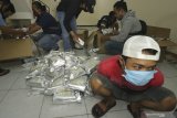 Seorang terduga pelaku peredaran narkotika yang diamankan oleh petugas Badan Narkotika Nasional Provinsi (BNNP) Jawa Timur saat penggerebekan sebuah ruko di kawasan Gunung Anyar, Surabaya, Jawa Timur, Rabu (9/9/2020) malam. Badan Narkotika Nasional Provinsi (BNNP) Jawa Timur menangkap tiga orang dalam penggerebek tersebut dan menyita sekitar delapan kilogram sabu yang dibungkus dalam kemasan bertuliskan 'Magnesium Chelate'. Antara Jatim/Didik/Zk