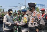 Kapolres Madiun Kota AKBP Raden Bobby Aria Prakasa (kiri) menyerahkan masker kepada anggota Polri saat  digelar apel Kampanye Penggunaan dan Pembagian Masker Serentak se-Indonesia di halaman Balai Kota Madiun, Jawa Timur, Kamis (10/9/2020). Pemkot Madiun bersinergi dengan TNI, Polri, Ormas dan relawan membagikan 10 ribu masker kemada masyarakat di sejulah lokasi guna pencegahan penularan COVID-19. Antara Jatim/Siswowidodo/zk.