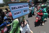 Warga Nahdlatul Ulama (NU) melakukan unjuk rasa di depan gedung Dewan Pengurus Cabang DPC PKB Kediri di Kediri Jawa Timur, Kamis (10/9/2020). Massa aksi menuntut pengembalian aset milik Pengurus Cabang Nahdlatul Ulama (PC NU) berupa gedung yang dipinjam PKB karena pencalonan bakal calon wakil bupati Dewi Maria Ulfa yang tidak mendapatkan restu dari kyai dan dinilai memanfaatkan nama besar NU untuk kepentingan golongan tertentu. Antara Jatim/Prasetia Fauzani/zk.