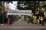 Petugas memasang spanduk larangan beraktivitas di Lapangan Puputan Badung, Denpasar, Bali, Minggu (13/9/2020). Pemerintah Kota Denpasar kembali menutup sejumlah ruang publik yang ramai dikunjungi masyarakat menyusul melonjaknya kasus penularan COVID-19 di Bali. ANTARA FOTO/Nyoman Hendra Wibowo/nym