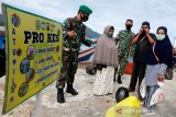 Prajurit TNI Kodam Iskandar Muda mensosialisasikan protokol kesehatan kepada penumpang dan ABK kapal kayu yang baru tiba dari pulau terluar di Ulee Lheu, Banda Aceh, Aceh, Senin (14/9/2020). Sosialisasi protokol kesehatan dengan mengajak dan mengimbau warga dari Pulau Nasi dan Pulau Aceh untuk memakai masker, menjaga jarak, mencuci tangan pakai sabun serta menghindari kerumunan tersebut sebagai upaya pencegahan penularan COVID-19 yang terus meningkat di seluruh Indonesia. Antara Aceh/Irwansyah Putra