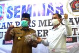 Gubernur Kalimantan Selatan Sahbirin Noor (kiri) menyerahkan bantuan masker yang diterima oleh Ketua Persatuan Wartawan Indonesia (PWI) Kalimantan Selatan Zainal Helmie (kanan) saat seminar PWI Kalsel di Gedung PWI Kalsel, Banjarmasin, Kalimantan Selatan, Senin (14/9/2020). PWI Kalsel menyelanggarakan seminar untuk jurnalis media cetak, online, tv, dan radio di Kalimantan Selatan dengan tema Peran Pers Mengawal Pemilu yang Bermartabat. Foto Antaranews Kalsel/Bayu Pratama S.