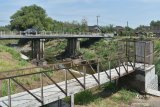 Pengendara melintasi jembatan yang membentang di atas Sungai Jeroan, Kabupaten Madiun, Jawa Timur, Senin (14/9/2020). Akibat musim kemarau Sungai Jeroan yang merupakan anak Sungai Madiun dan airnya dibutuhkan petani untuk irigasi tersebut mulai mengering. Antara Jatim/Siswowidodo/zk