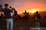 Wisatawan lokal menikmati matahari terbenam (sunset) dibukit singgah mata, Kabupaten Aceh Barat Daya, Aceh, Ahad (13/9). Bukit singgah mata dengan ketinggian 1000 kaki tersebut terletak di kilometer 21 jalan Ie Mirah, Babahrot-Terangun, Gayo Lues menjadi alternatif menikmati matahari terbenam dengan pemandangan puncak pengunungan. Antara Aceh/Suprian.