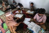 Dua orang guru sekolah dasar mengajar di rumah muridnya di Kelurahan Pesantren, Kota Kediri, Jawa Timur, Selasa (15/9/2020). Pembelajaran kelompok kecil di rumah siswa sekali dalam sebulan tersebut sebagai evaluasi penguasan materi pelajaran sekaligus upaya penyegaran agar siswa tidak bosan mengikuti pembelajaran jarak jauh. Antara Jatim/Prasetia Fauzani/zk