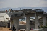 Pekerja menyelesaikan proyek jalan layang yang dibangun untuk menggantikan jalan yang digusur oleh proyek Kereta Cepat Jakarta Bandung di Tegalluar, Kabupaten Bandung, Jawa Barat, Rabu (16/9/2020). Wakil Menteri BUMN Kartika Wirjoatmodjo menyatakan, proyek kereta cepat Jakarta-Bandung telah mencapai 56 persen dan ditargetkan akan dapat digunakan pada awal tahun 2023. ANTARA JABAR/Raisan Al Farisi/agr