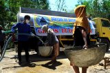 Relawan memasukkan air ke dalam timba saat pendistribusian air bersih di Desa Pamoroh, Pamekasan, Jawa Timur, Kamis (17/9/2020). Distribusi air bersih yang disalurkan oleh Forum Relawan Penanggulangan Bencana (FRPB) yang dilakukan sejak beberapa waktu lalu, guna membantu warga yang terdampak kekeringan akibat musim kemarau. Antara Jatim/Saiful Bahri/zk