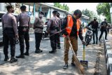 Warga yang melanggar protokol kesehatan menyapu bahu jalan saat terjaring Operasi Yustisi Protokol COVID-19 di kawasan Jati Padang, Jakarta, Kamis (17/9/2020). Polda Metro Jaya dalam operasi gabungan tersebut hingga Selasa (15/9) mencatat telah memberikan sanksi terhadap 9.734 pelanggar PSBB Jakarta dengan nilai denda sebesar Rp88,6 juta. ANTARA FOTO/Aprillio Akbar/nym.