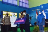 Gubernur Jawa Timur Khofifah Indar Parawansa (kedua kiri) menyerahkan secara simbolis bantuan kartu internet gratis dari XL Axiata saat melakukan kunjungan kerja di SMAN 2 Mejayan Kabupaten Madiun, Jawa Timur, Jumat (18/9/2020). PT XL Axiata Tbk memberikan bantuan internet gratis sebanyak 1,3 juta kartu kepada siswa SMA, SMK, SLB dan 100.000 kartu untuk guru di Jawa Timur guna mendukung program belajar secara daring saat masa pandemi COVID-19. Antara Jatim/Siswowidodo/zk