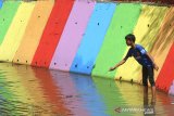 Seorang anak bermain di Sungai Kemuning di Kelurahan Kemuning, Banjarbaru, Kalimantan Selatan, Jumat (18/9/2020). Bank Rakyat Indonesia (BRI) melalui program Tanggung Jawab Sosial Perusahaan (Corporate Social Responsibility/CSR) melakukan konservasi Sungai Kemuning dengan membersihkan dan memberikan edukasi lingkungan sehat kepada masyarakat serta membangun sarana dan prasarana seperti ruang terbuka hijau dan area taman yang dapat dimanfaatkan oleh masyarakat sebagai fasilitas umum. Foto Antaranews Kalsel/Bayu Pratama S.