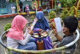 Anak-anak membaca buku dan bermain di Kampung Ramah Anak, Babakan Kalangsari, Kota Tasikmalaya, Jawa Barat, Selasa (22/9/2020). Kampung ramah anak yang menyediakan fasilitas permainan tradisional sekaligus taman bacaan itu bertujuan untuk mengajarkan anak bersosialisasi dan membudayakan gotong royong, agar anak-anak terhidar dari bahaya negatif perkembangan zaman khususnya teknologi. ANTARA JABAR/Adeng Bustomi/agr