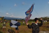 Peserta bersiap menerbangkan layang-layang tradisional saat mengikuti Festival Layang-layang di lapangan Desa Candimulyo, Dolopo, Kabupaten Madiun, Jawa Timur, Rabu (23/9/2020). Festival yang diikuti 120 peserta tersebut dimaksudkan untuk melestarikan permainan tradisional layang-layang. Antara Jatim/Siswowidodo/zk