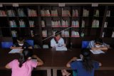 Sejumlah siswa SD mengikuti kegiatan belajar menulis aksara Bali di Perpustakaan Sabha Widya Sradha, Desa Sumerta Kelod, Denpasar, Bali, Kamis (24/9/2020). Perpustakaan yang dikelola desa tersebut digunakan untuk tempat belajar siswa pada masa pandemi COVID-19 secara bergantian dengan menerapkan protokol kesehatan. ANTARA FOTO/Nyoman Hendra Wibowo/nym.