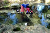 Warga mencuci pakaian di sungai yang airnya mulai tidak mengalir di Desa Blumbungan, Pamekasan, Jawa Timur, Kamis (24/9/2020). Pada musim kemarau tahun ini, sebanyak 311 dusun dari 77 desa di kabupaten itu, terdampak kekeringan. Antara Jatim/Saiful Bahri/zk