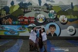 Warga berswafoto di mural tentang Kota Bandung Oded M. Danial di Taman Sejarah, Bandung, Jawa Barat, Jumat (25/9/2020). Pemerintah Kota Bandung menyediakan mural tentang Kota Bandung dan Selubung foto Wali Kota Bandung dari masa ke masa sebagai peringatan Hari jadi Ke-210 Kota Bandung yang menjadi lokasi wisata swafoto dan wisata edukasi bagi masyarakat. ANTARA JABAR/Novrian Arbi/agr