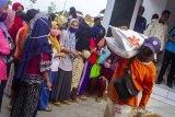 Warga membawa beras program bantuan sosial di Kantor Desa Majalaya, Karawang, Jawa Barat, Jumat (25/9/2020). Kementerian Sosial menyalurkan bantuan sosial beras kepada 10 juta Keluarga Penerima Manfaat Program Keluarga Harapan (KPM-PKH) untuk mengurangi beban pengeluaran kebutuhan pangan beras saat pandemi COVID-19. ANTARA JABAR/M Ibnu Chazar/agr
