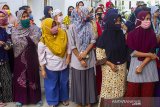 Warga menunggu giliran untuk menerima bantuan sosial beras di Kantor Desa Majalaya, Karawang, Jawa Barat, Jumat (25/9/2020). Kementerian Sosial menyalurkan bantuan sosial beras kepada 10 juta Keluarga Penerima Manfaat Program Keluarga Harapan (KPM-PKH) untuk mengurangi beban pengeluaran kebutuhan pangan beras saat pandemi COVID-19. ANTARA JABAR/M Ibnu Chazar/agr