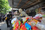 Pesilat membagikan masker kepada pedagang di Pasar Kutisari, Surabaya, Jawa Timur, Jumat (25/9/2020). Polsek Tenggilis bersama sejumlah pesilat dari berbagai perguruan silat di Surabaya membagikan ratusan masker kepada pedagang pasar dan warga yang bertujuan untuk memberikan pemahaman dan meningkatkan disiplin masyarakat menerapkan protokol kesehatan. Antara Jatim/Didik/Zk