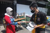 Pesilat membagikan masker kepada pedagang di Pasar Kutisari, Surabaya, Jawa Timur, Jumat (25/9/2020). Polsek Tenggilis bersama sejumlah pesilat dari berbagai perguruan silat di Surabaya membagikan ratusan masker kepada pedagang pasar dan warga yang bertujuan untuk memberikan pemahaman dan meningkatkan disiplin masyarakat menerapkan protokol kesehatan. Antara Jatim/Didik/Zk