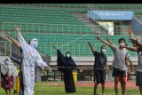 Petugas medis (kiri) memimpin senam pagi bersama pasien COVID-19 berstatus Orang Tanpa Gejala (OTG) di Stadion Patriot Chandrabhaga, Bekasi, Jawa Barat, Senin (28/9/2020). Olahraga pagi yang dilakukan rutin setiap hari oleh 25 pasien tersebut untuk meningkatkan imunitas tubuh selama menjalankan isolasi. ANTARA FOTO/Fakhri Hermansyah/nym.