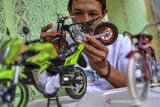 Pekerja menyelesaikan pembuatan miniatur sepeda motor di desa Sinasari, Kabupaten Tasikmalaya, Jawa Barat, Selasa (29/9/2020). Miniatur sepeda motor berbahan limbah dari kartu perdana, karet, korek gas, kawat, kaleng minuman dan korek kuping ini dijual dengan harga Rp500 ribu - Rp1 juta per buah yang dipasarkan melalui platform digital. ANTARA JABAR/Adeng Bustomi/agr