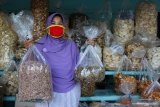 Pedagang menunjukkan produk pangan olahan hasil laut di salah satu toko di kawasan Sukolilo Larangan, Surabaya, Jawa Timur, Selasa (29/9/2020). Di kawasan wisata pesisir pantai yang dekat dengan Jembatan Suroboyo tersebut terdapat puluhan toko yang menjual berbagai  macam produk pangan olahan hasil laut diantaranya krupuk ikan, rambak kulit ikan, ikan asin, krupuk teripang, kerupuk terung dan lain sebagainya dengan harga bervariasi. Antara Jatim/Didik/Zk