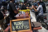 Barista membagikan kopi gratis kepada pengguna jalan dalam peringatan Hari Kopi Internasional di jalan Siguragura, Malang, Jawa Timur, Kamis ( 1/10/2020). Kegiatan bagi-bagi 1000 cangkir kopi gratis tersebut sekaligus dimanfaatkan untuk memperkenalkan kopi Nusantara kepada masyarakat. Antara Jatim/Ari Bowo Sucipto/zk