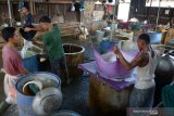 Perajin menuangkan cairan kacang kedelai saat proses produksi tahu di salah satu usaha industri tahu tradisional, Banda Aceh, Aceh, Kamis (1/10/2020). Asosiasi Perangrajin Tahu Tempe Aceh menyatakan, sejak pandemi COVID-19 harga bahan baku kedalai impor terus mengalami kenaikan hingga saat ini mencapai Rp8.000 perkilogram dari sebelumnya Rp6.700 hingga Rp7.200 perkilogram sehingga berdampak pada produksi tahu turun kisara 30 persen, sedangkan harga penjualan tahu tidak dinaikan di tingkat pengecer tetap Rp33.000 per papan guna menjaga stabilitas pasar dan pelanggan. Antara Aceh/Ampelsa.


