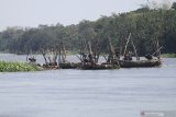 Pekerja menambang pasir menggunakan perahu di tengah aliran sungai Brantas, Kota Kediri, Jawa Timur, Kamis (1/10/2020). Aktivitas penambangan ilegal di sungai itu tetap marak meskipun petugas Satuan Polisi Pamong Praja gencar melakukan razia karena dinilai merusak lingkungan dan mengancam keberadaan jembatan di wilayah sekitar. Antara Jatim/Prasetia Fauzani/zk