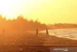 Pengunjung menikmati suasana matahari terbenam di Pantai Tiris, Pasekan, Indramayu, Jawa Barat, Kamis (1/10/2020). Objek wisata pantai Tiris yang dikelola desa setempat menjadi salah satu tujuan wisata baru di Pantai Utara Indramayu dengan menawarkan pantai yang luas dan kawasan konservasi pengamatan migrasi burung. ANTARA JABAR/Dedhez Anggara/agr