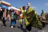 Ibu-ibu mengikuti parade batik untuk memperingati Hari Batik Nasional di depan pasar Karangploso, Malang, Jawa Timur, Jumat ( 2/10/2020). Kegiatan tersebut diadakan untuk mengenalkan motif batik nusantara sekaligus mengkampanyekan penggunaan masker guna pencegahan COVID-19. Antara Jatim/Ari Bowo Sucipto/zk.