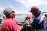 Nelayan mengisi bahan bakar kapal di Pelabuhan Ikan Muncar Banyuwangi, Jawa Timur, Jumat (2/10/2020). Pemerintah menyiapkan stimulus sebesar Rp34 triliun untuk pembayaran angsuran dan pemberian subsidi bunga kredit bagi petani dan nelayan guna meringankan biaya produksi selama masa pandemi COVID-19. Antara Jatim/Budi Candra Setya/zk.