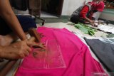 Perajin memberi motif daun pada selembar kain dengan menggunakan teknik 'ecoprint' di Shantika Fashion, Surabaya, Jawa Timur, Jumat (2/10/2020). Lembaran-lembaran kain bermotif berbagai jenis daun tersebut dijual ke berbagai daerah dengan harga Rp150.000 sampai Rp1.500.000 per lembar tergantung bahan kain, ukuran dan tingkat kesulitan. Antara Jatim/Didik/Zk
