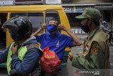 Petugas Linmas meminta warga untuk memakai masker sebelum memasuki wilayah Kelurahan Setiamanah, Cimahi, Jawa Barat, Senin (5/10/2020). Pemerintah Kota Cimahi menerapkan 