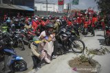 Pengendara yang terjebak kemacetan di jalan nasional Bandung-Garut-Tasikmalaya saat aksi buruh di Rancaekek mengangkat motornya untuk pindah jalur di Kabupaten Bandung, Jawa Barat, Selasa (6/10/2020). Aksi tersebut merupakan penolakan buruh terhadap pengesahan UU Cipta Kerja yang telah disahkan oleh DPR. ANTARA JABAR/Raisan Al Farisi/agr